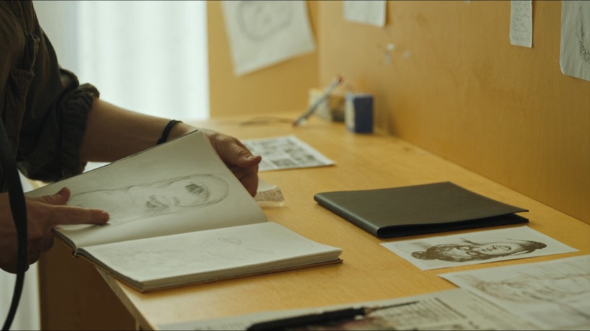 Alumna revisando su cuaderno mientras construye un estilo propio como tatuadora