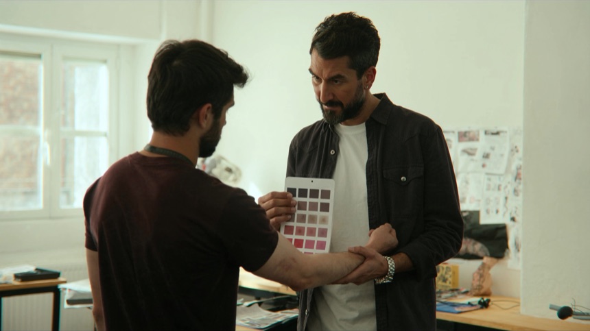 Mentora contrastando una carta de color con la piel, clave en teoria del color en tatuaje